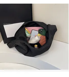Dettaglio interno di borsa in nylon nero con spazio per laptop, ombrello e oggetti quotidiani