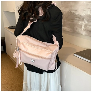 Détails du sac à bandoulière en nylon rose avec anse froncée et broderie ours
