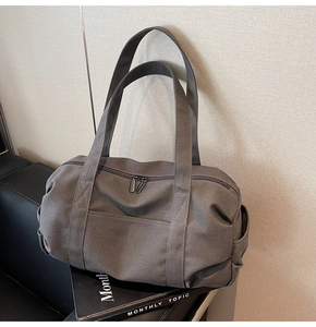Detail of dark grey canvas travel bag with sturdy handles and side pocket storage