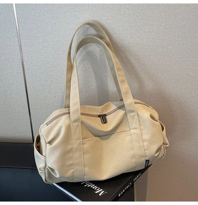 Detail of the high-density beige canvas travel bag on a book with sturdy shoulder straps