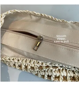 Detail shot of the smooth metal zipper and beige lining on this large straw tote bag