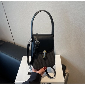 Detail of black contrast texture handbag with silver J-shaped metal buckle and strap