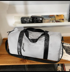 Détail du sac de sport étanche en nylon avec sangles renforcées sur étagère bois