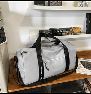 Détail du sac de sport en nylon étanche avec bandoulière réglable sur bureau en bois