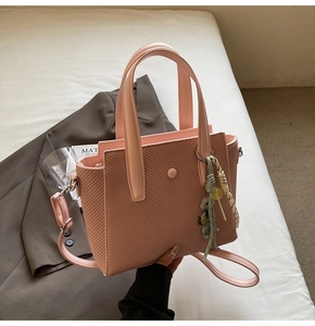 Vue détaillée du sac seau tissé rose avec ruban en soie et bandoulière amovible