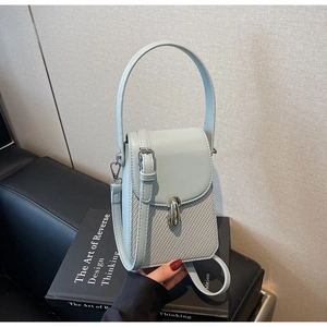 Close-up of light blue mini handbag with woven leather texture and metal lock detail
