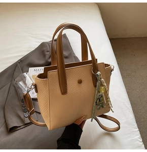 Détails du sac seau tissé avec poignées en cuir et charmant accessoire d'ours en peluche