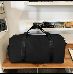 Sac de fitness noir étanche de grande capacité posé sur un bureau en bois