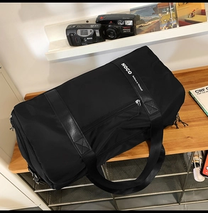 Détail du sac de sport en nylon étanche avec logo NOCO sur table en bois chic