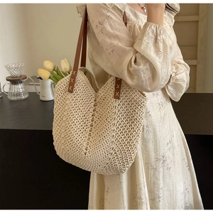 Detail of hand-woven beige cotton tote with premium brown leather straps and X-stitch sewing