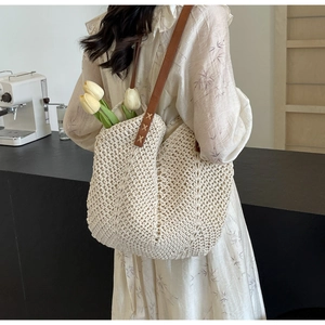 Detail of cream crochet shoulder bag with brown leather handle and hollow wave texture