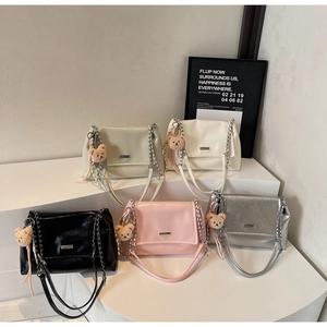 Group view of soft leather tote bags in five colors with cute bear charms on a white stand