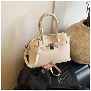 Detail of elegant beige crossbody bag with silver H-shaped buckle and luxury leather texture