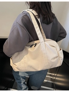 Large off-white canvas travel tote bag with wide shoulder straps for sports and gym