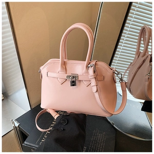 Detail view of pink crossbody handbag featuring silver metal clasp and smooth leather finish