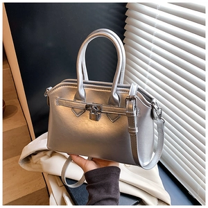 Detail of silver metallic handbag with textured finish and elegant padlock hardware