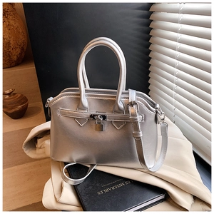 Close-up of bright silver handbag with metallic lock detail and stylish round handles