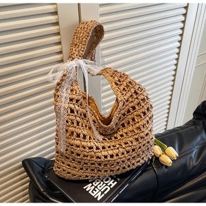 Detail of hollow-out straw tote bag with white lace bow and yellow tulip decoration