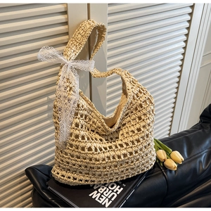 Detail of hand-woven straw tote bag with elegant white lace bow on side