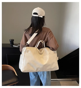 Dettaglio di una grande borsa tote beige in ecopelle con texture e tasca laterale