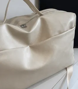 Dettaglio della grande borsa tote crema che mostra la morbida pelle PU e la tasca laterale