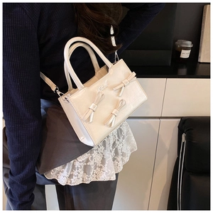 Detail of white bow square handbag with Chord logo on matte PU leather material