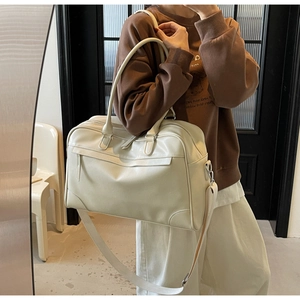 Détail du sac de voyage Boston crème montrant sa grande capacité et ses poignées