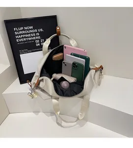 Spacious interior of a beige travel bag filled with gadgets, umbrella and daily essentials