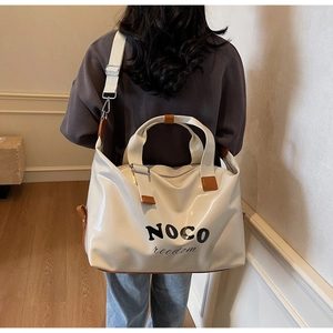 Detailed back view of a large capacity cream travel bag with brown leather handles and straps