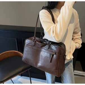 Gros plan du sac de voyage en cuir marron foncé avec logo OFFBETTER et zip en métal