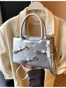 Silver bow-accented square handbag with pearls and metallic finish for crossbody wear