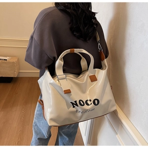 Cream large travel tote bag with brown leather accents and detachable shoulder strap