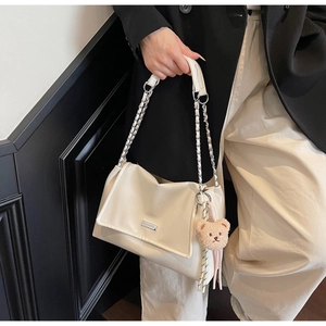 Detail of cream white PU leather tote with chain strap and cute bear charm pendant