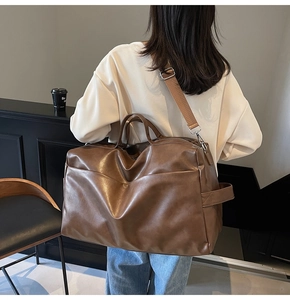 Dettaglio della borsa tote marrone che mostra la trama in pelle e la tracolla larga