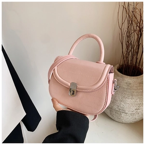 Detail of pink faux lizard texture saddle bag with elegant silver twist lock and handle