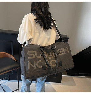 Detail of charcoal grey canvas travel bag with SUBEEN NOON logo and shoulder strap