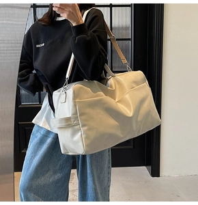 Dettaglio della grande borsa tote in pelle PU crema con manico laterale e tracolla larga