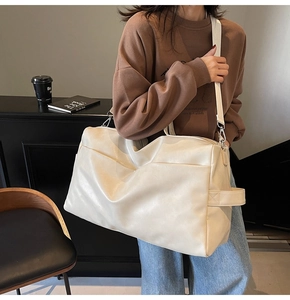 Dettaglio della borsa tote in ecopelle color crema con texture e tracolla regolabile