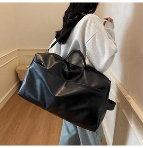 Dettaglio della grande borsa tote minimalista in pelle PU nera con ampie tracolle