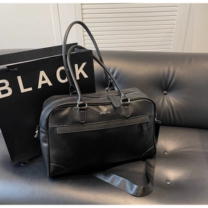 Gros plan du sac de voyage noir Offbetter en similicuir avec bandoulière et poignées chic
