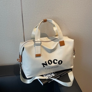 Large cream PU travel bag with NOCO text on black leather sofa in modern setting