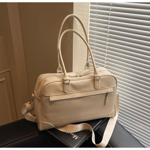 Détail du sac de voyage crème avec texture cuir et logo OFFSETTER embossé dessus