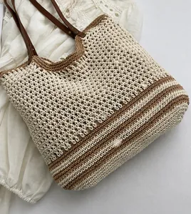 Detail of woven tote bag showing cotton stripe pattern and leather strap with rivets