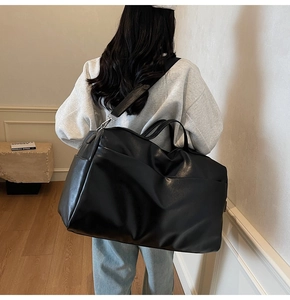 Vista posteriore di una modella con una grande borsa tote retrò nera con tracolla larga