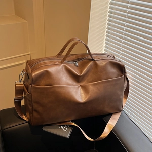 Dettaglio della borsa tote grande marrone scuro con tracolla regolabile e zip metallica