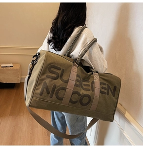 Close-up of olive green canvas travel bag with durable woven handles and shoulder strap