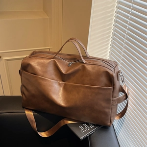 Vista dettagliata della borsa tote in pelle marrone scuro su una sedia con luce naturale