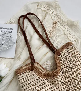 Close-up of woven hollow mesh tote with brown leather straps and beige inner lining