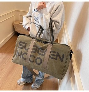 Detailed view of the woven handles and heavy-duty canvas fabric on green travel bag