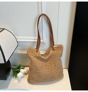 Detalle del bolso tote de punto calado con correas de cuero sintético marrón y remaches